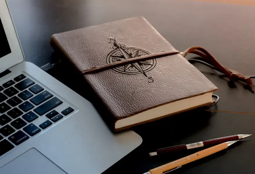 decor - notebook with a compass rose print next to a laptop