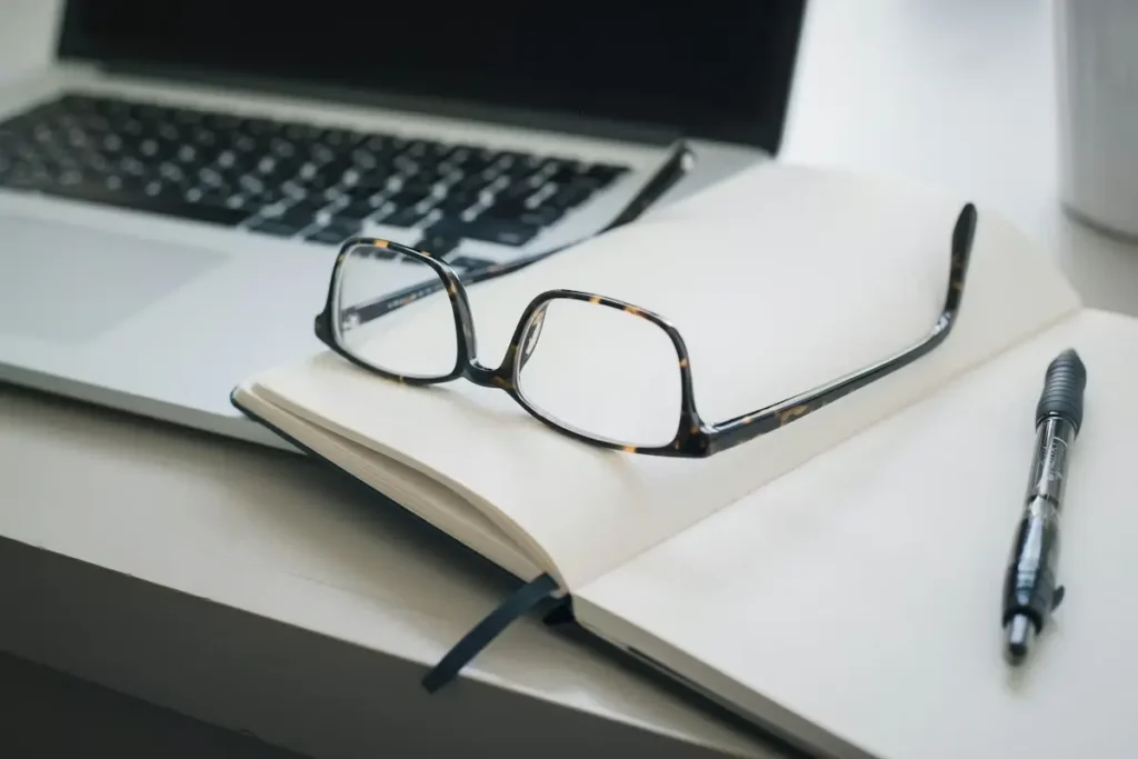 decor - laptop, notebook, glasses and pen on a work desk representing insurance agency audit